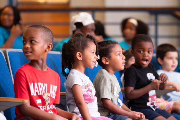 children watching a performance happily