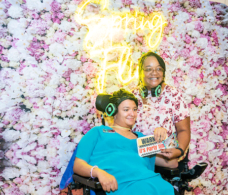 two women in front of a flower wall that says "Spring Fling"