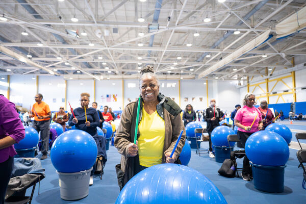 A group of senior adults participating in a drum and tone class inside.